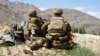 US -- (FILES) In this file photo taken on June 6, 2019 US soldiers look out over hillsides during a visit of the commander of US and NATO forces in Afghanistan General at the Afghan National Army (ANA) checkpoint in Nerkh district of Wardak province. - An