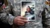 IRAN -- A demonstrator holds the picture of Qassem Soleimani during a protest against the assassination of the Iranian Major-General Qassem Soleimani, head of the elite Quds Force, and Iraqi militia commander Abu Mahdi al-Muhandis who were killed in an ai