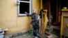 UKRAINE -- Local resident Valentyna Petrenko, 52, shows a broken window of her house in the settlement of Druzhba, located near the scene of explosions at a defence ministry ammunition depot in the eastern Chernihiv region, October 9, 2018