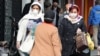 Iranian women wearing face mask walk past in a street of Tehran, Iran, 26 February 2020.